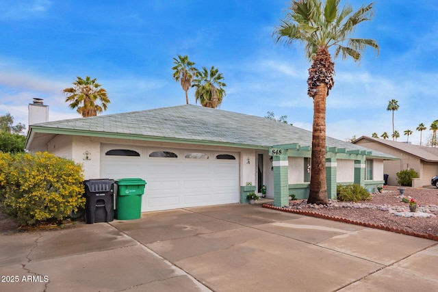 ranch-style house with a garage, concrete driveway, and stucco siding