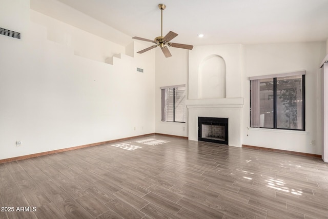 3740 W Kent Dr, Chandler, AZ 85226 - unfurnished living room with a large fireplace, wood finished floors, a ceiling fan, baseboards, and recessed lighting