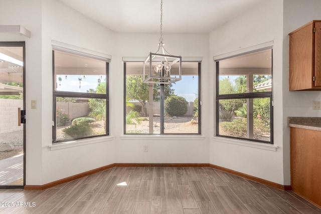 3740 W Kent Dr, Chandler, AZ 85226 - unfurnished dining area featuring a chandelier, wood finished floors, and baseboards
