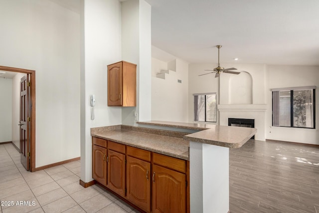 3740 W Kent Dr, Chandler, AZ 85226 - kitchen featuring a peninsula, ceiling fan, a glass covered fireplace, open floor plan, and baseboards