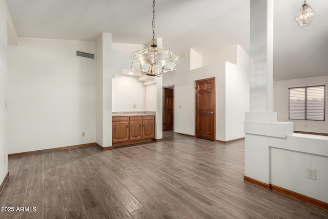 3740 W Kent Dr, Chandler, AZ 85226 - unfurnished living room featuring a chandelier, dark wood-style flooring, high vaulted ceiling, and baseboards