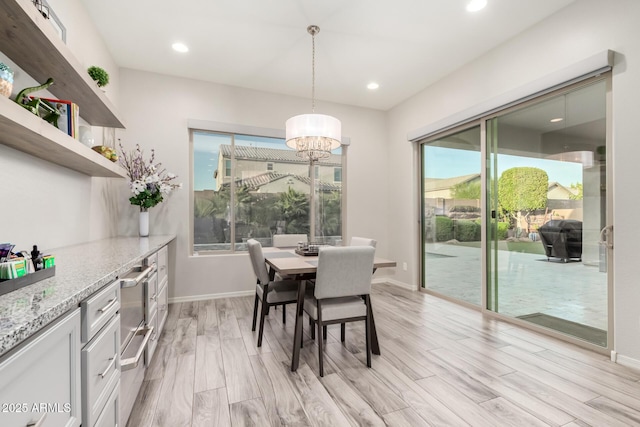 dining room with light wood-type flooring, baseboards, a notable chandelier, and recessed lighting