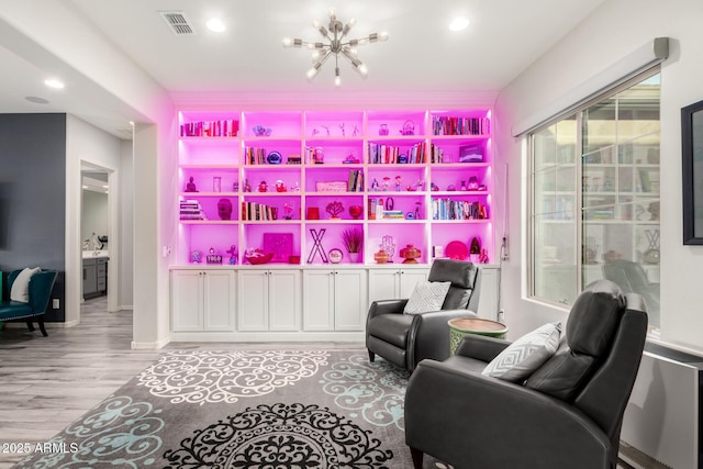 sitting room featuring a chandelier, wood finished floors, visible vents, and recessed lighting