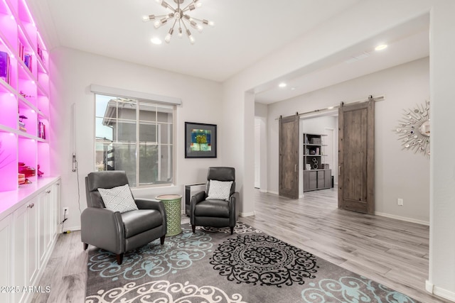 living area with a barn door, baseboards, wood finished floors, a notable chandelier, and recessed lighting