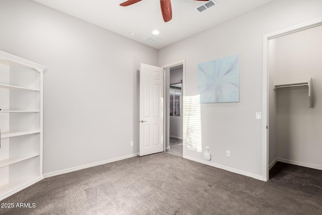 unfurnished bedroom with baseboards, visible vents, a spacious closet, carpet flooring, and a closet