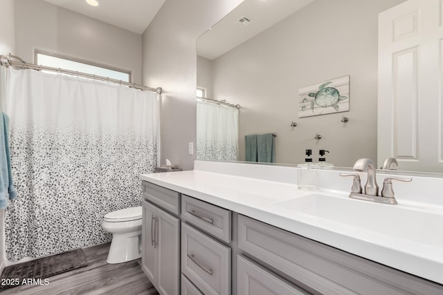 full bathroom featuring visible vents, toilet, a shower with curtain, wood finished floors, and vanity