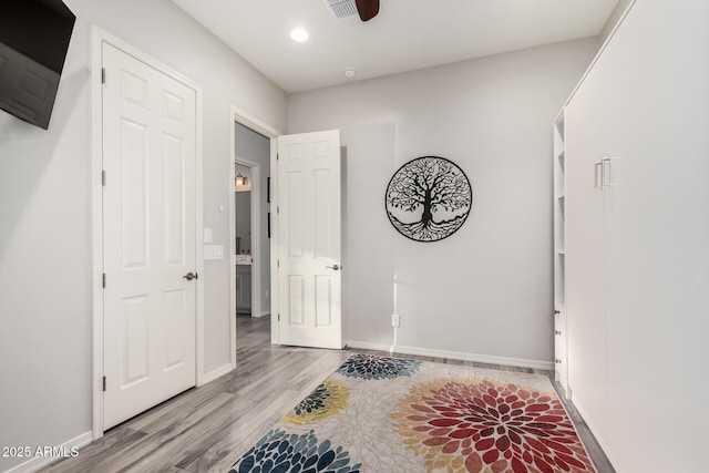 interior space featuring visible vents, baseboards, wood finished floors, and recessed lighting