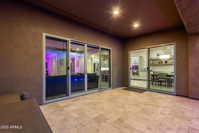 entrance to property with a patio and stucco siding