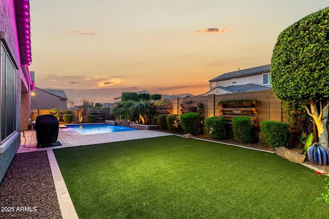 pool at dusk with a patio, a lawn, a grill, and a fenced backyard