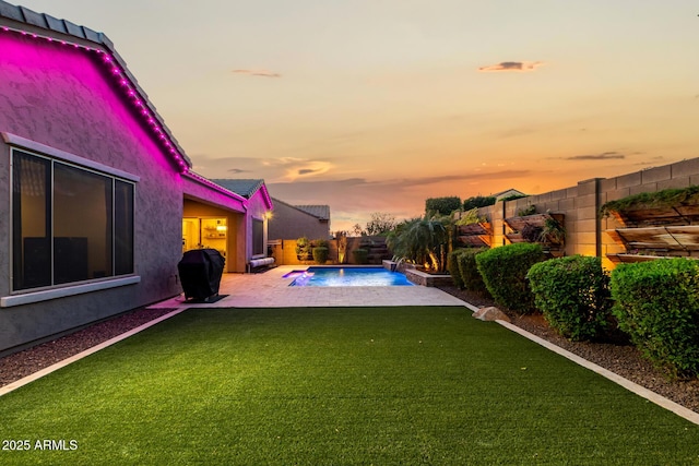 pool at dusk with a fenced in pool, a patio, a lawn, a fenced backyard, and a grill