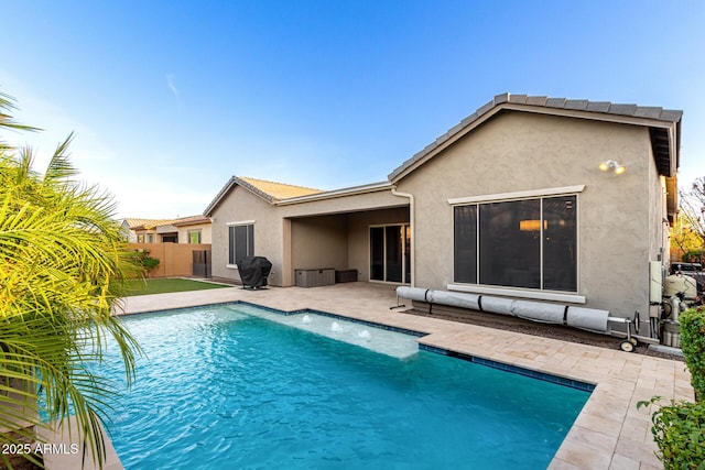 rear view of house featuring a fenced in pool, fence, a patio, and stucco siding