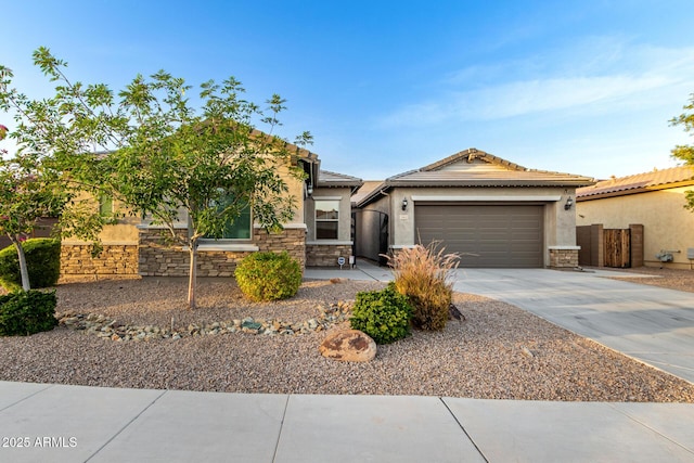 view of front of home featuring an attached garage, stone siding, driveway, and stucco siding