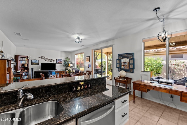 kitchen featuring dishwasher, sink, dark stone counters, decorative light fixtures, and white cabinets