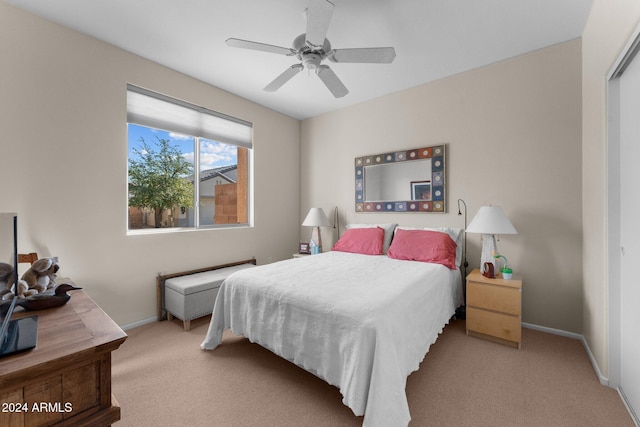 bedroom featuring ceiling fan, light carpet, and a closet