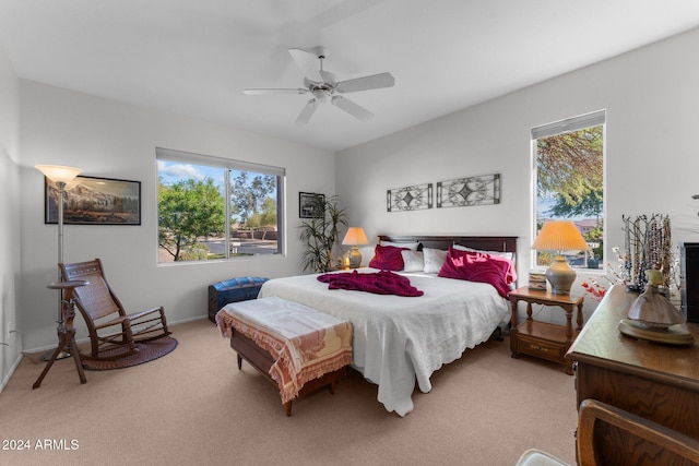 carpeted bedroom with multiple windows and ceiling fan