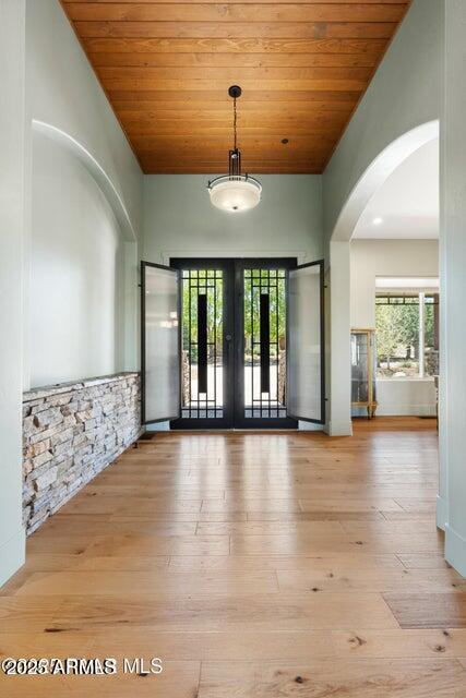 1568 Gettysvue Way, Prescott, AZ 86301 - empty room featuring wooden ceiling, arched walkways, french doors, light wood finished floors, and a high ceiling