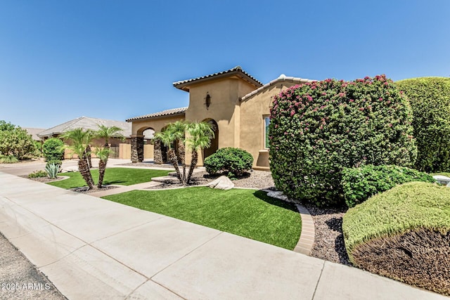 7242 W Rowel Rd, Peoria, AZ 85383 - mediterranean / spanish house with stucco siding, a tiled roof, and a front lawn