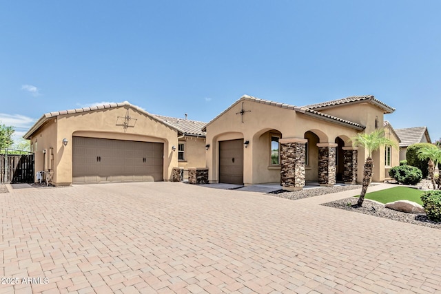 7242 W Rowel Rd, Peoria, AZ 85383 - mediterranean / spanish house with an attached garage, stucco siding, decorative driveway, and a tiled roof