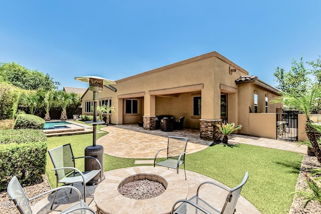 7242 W Rowel Rd, Peoria, AZ 85383 - back of property featuring an outdoor fire pit, a patio, stucco siding, and a gate