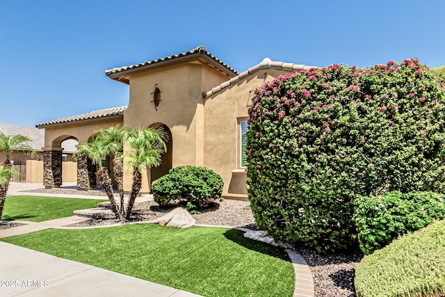 7242 W Rowel Rd, Peoria, AZ 85383 - mediterranean / spanish house featuring stucco siding, a front yard, and a tiled roof