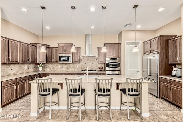 7242 W Rowel Rd, Peoria, AZ 85383 - kitchen with appliances with stainless steel finishes, wall chimney exhaust hood, a kitchen island with sink, decorative backsplash, and recessed lighting