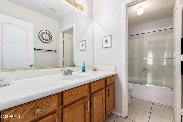 full bathroom with tile patterned floors, toilet, vanity, and combined bath / shower with glass door