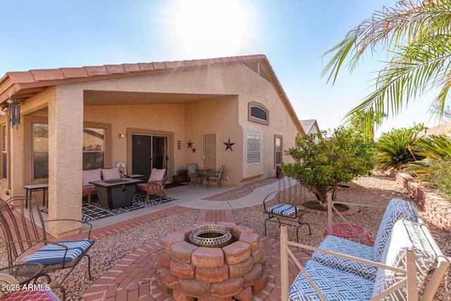 back of house with a patio and an outdoor living space with a fire pit