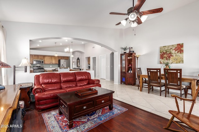 tiled living room with ceiling fan and lofted ceiling