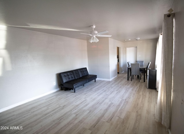 living area with light hardwood / wood-style flooring and ceiling fan