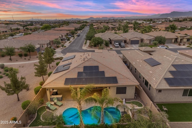 aerial perspective of suburban area with a mountainous background and a pool