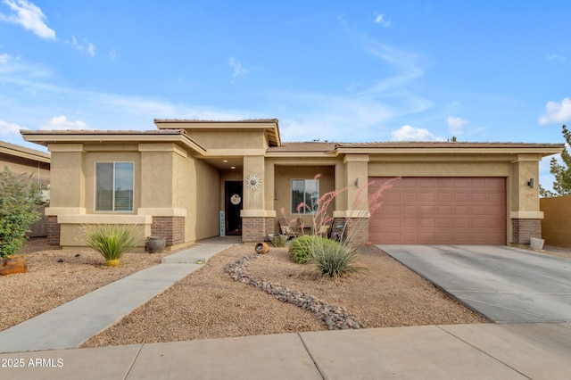 prairie-style house with stucco siding, concrete driveway, a garage, and brick siding