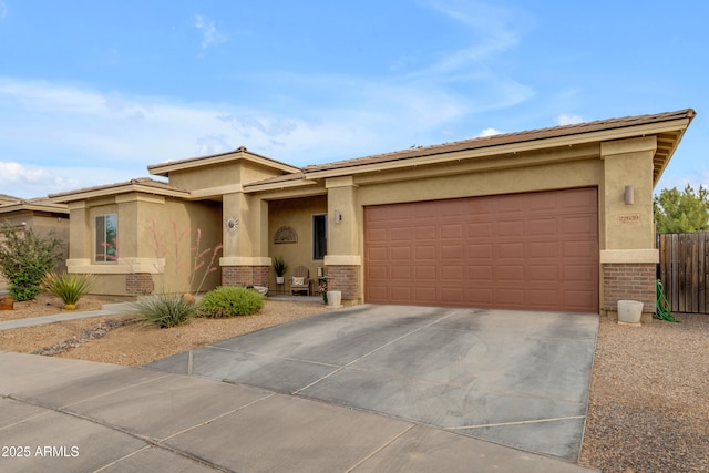 prairie-style house with brick siding, stucco siding, concrete driveway, and a garage