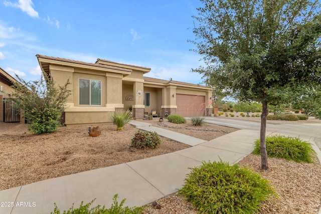 view of front facade featuring concrete driveway, stucco siding, an attached garage, and a tile roof