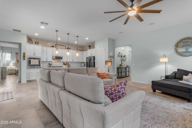 living room with ceiling fan and recessed lighting