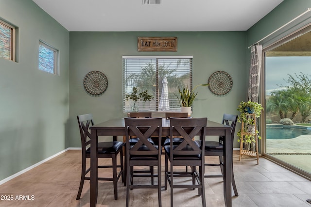 tiled dining room featuring baseboards
