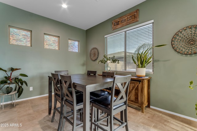 dining space featuring baseboards and light tile patterned flooring
