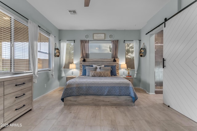 bedroom featuring a barn door, baseboards, and multiple windows
