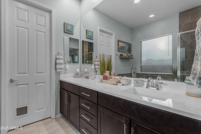 bathroom featuring double vanity and tiled shower