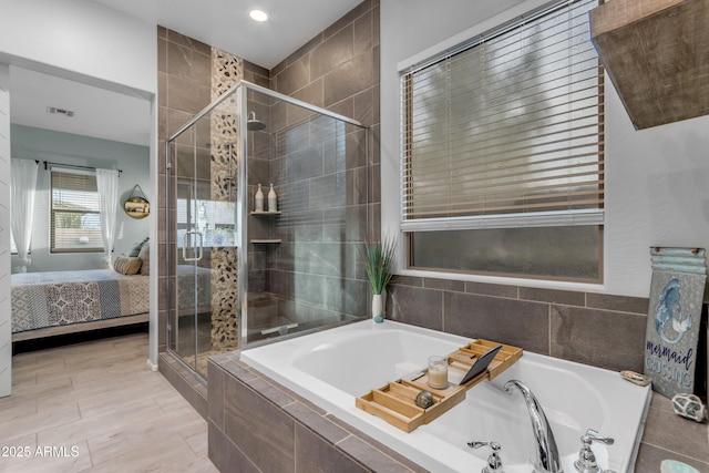 ensuite bathroom with a shower stall, a garden tub, and recessed lighting