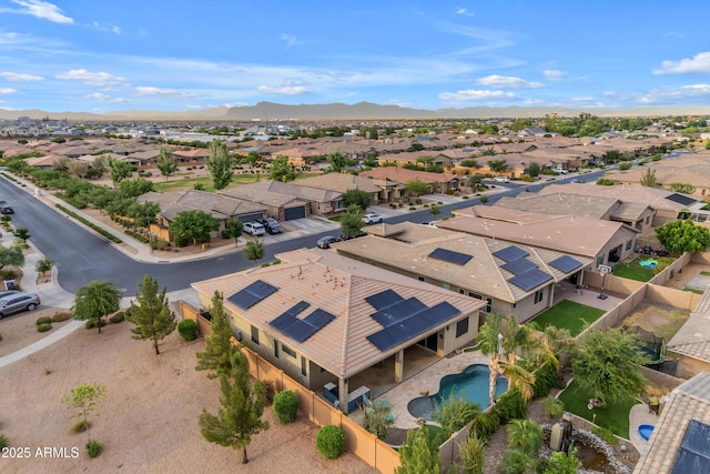 aerial perspective of suburban area with a pool and a mountain backdrop