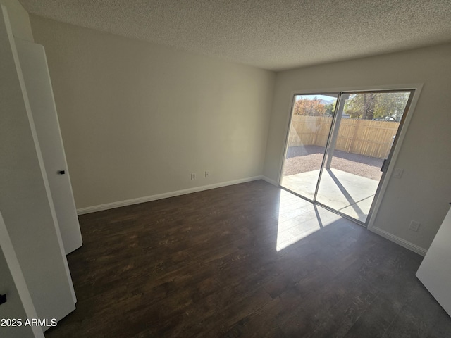 spare room with dark hardwood / wood-style flooring and a textured ceiling