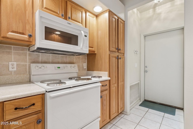 kitchen with light tile patterned flooring, white appliances, and tasteful backsplash