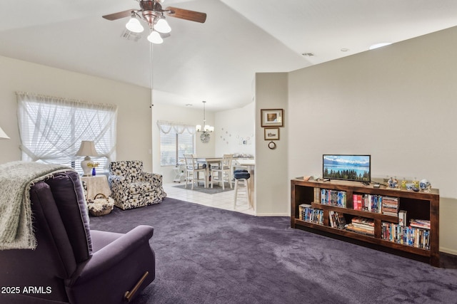 carpeted living room featuring lofted ceiling and ceiling fan with notable chandelier