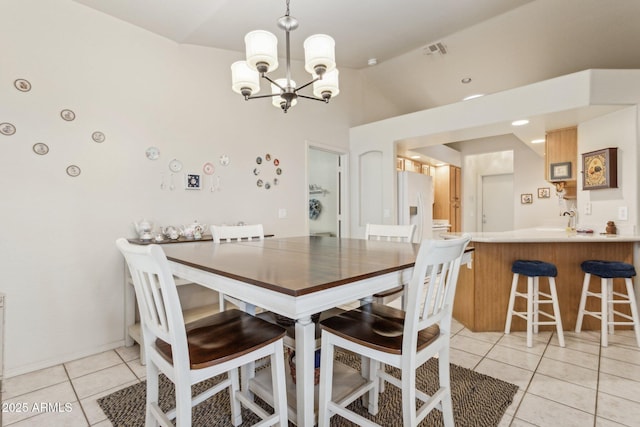 tiled dining room featuring sink and an inviting chandelier