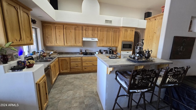 2926 W Tanya Trl, Phoenix, AZ 85086 - kitchen featuring stainless steel appliances, under cabinet range hood, a sink, tile countertops, and a kitchen breakfast bar
