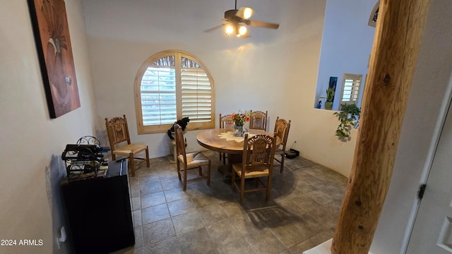 dining room with ceiling fan and a high ceiling