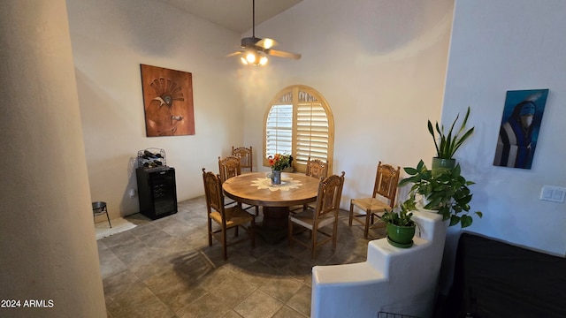 dining space with ceiling fan and high vaulted ceiling