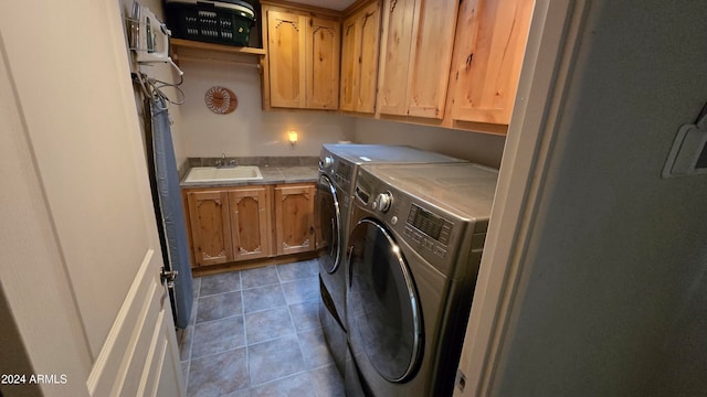 laundry area with dark tile patterned floors, cabinets, separate washer and dryer, and sink