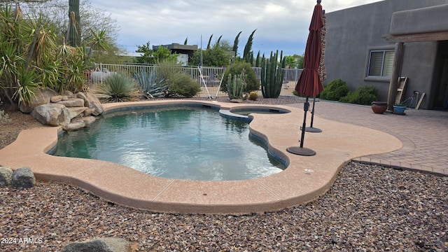 view of swimming pool featuring an in ground hot tub and a patio area