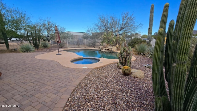 view of swimming pool featuring an in ground hot tub and a patio